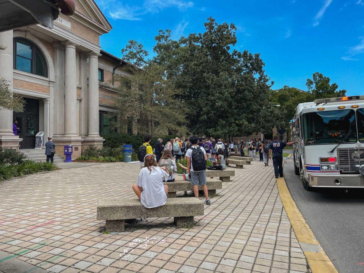 Students stand outside of the Journalism Building on Tuesday, Sept. 13, 2022, as a fire truck pulls up on Field House Drive in Baton Rouge, La.