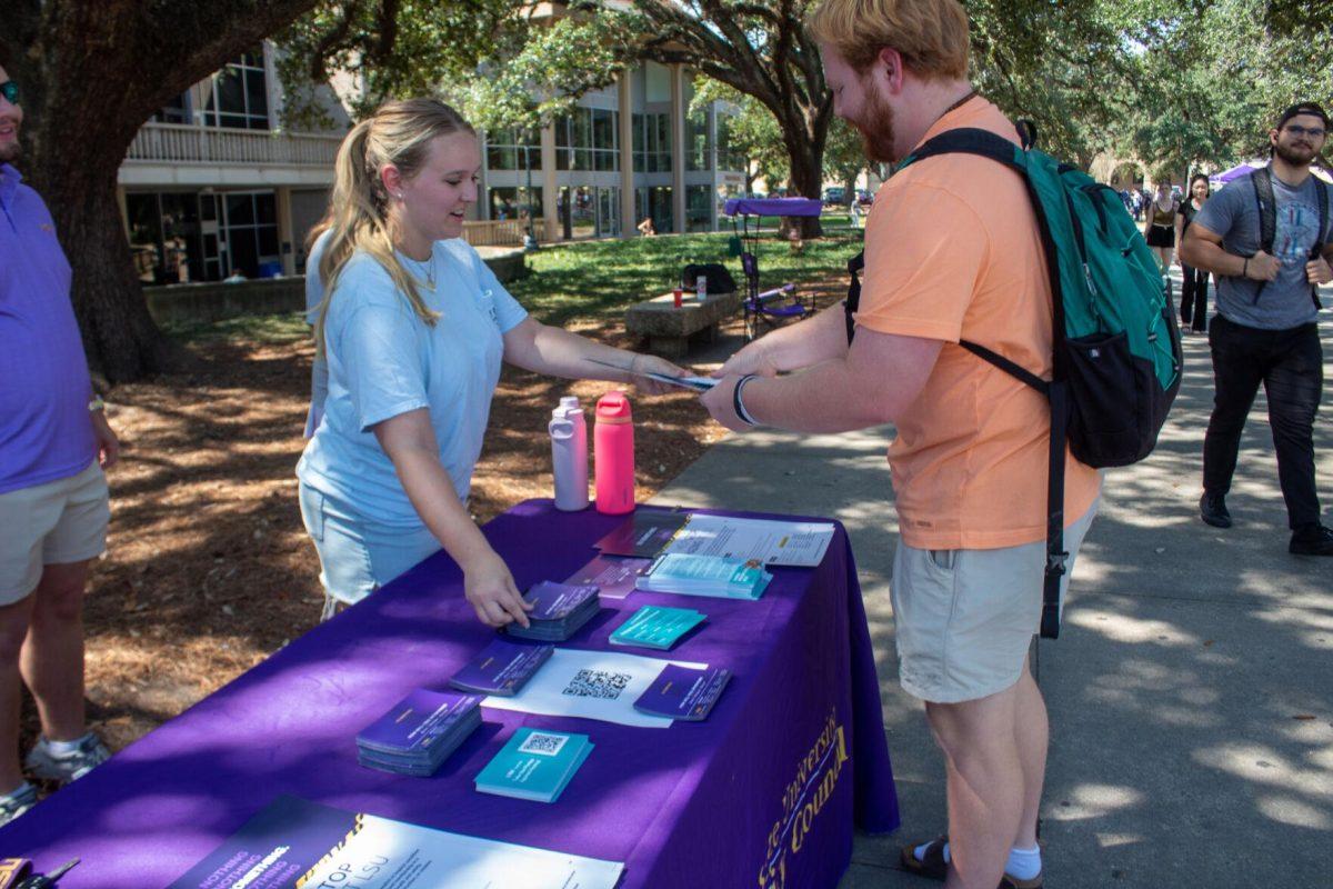 A student is handing informational flyers about hazing prevention on Tuesday, Sept 20, 2022, in Free Speech Alley on LSU's Campus.