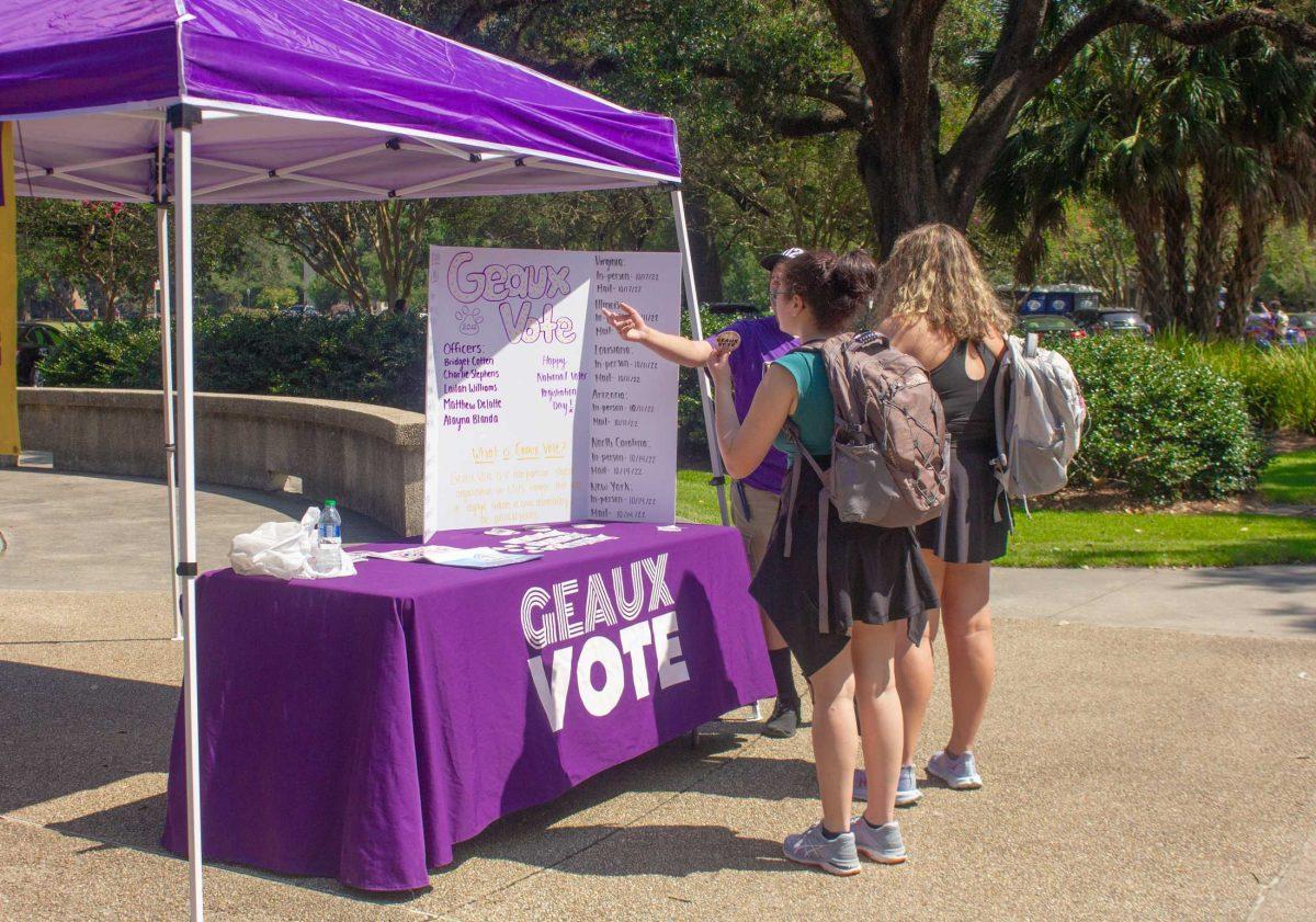 Students read the poster at the Geaux Vote tent on Tuesday, Sept. 20, 2022, in Free Speech Plaza on Tower Drive in Baton Rouge, La.