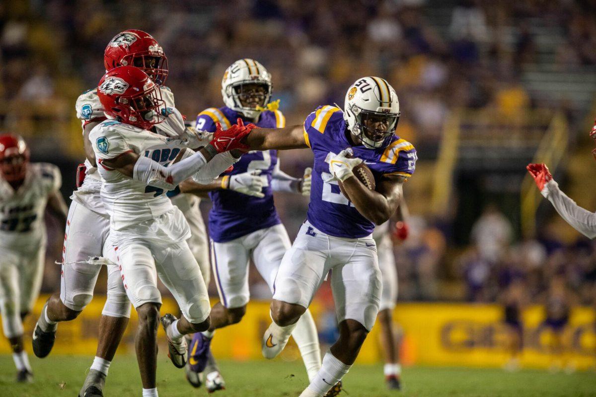 LSU football junior running back Noah Cain (21) guards the ball from New Mexico players on Saturday, Sept. 24, 2022, during the LSU vs New Mexico game in Tiger Stadium&#160;in Baton Rouge, La.