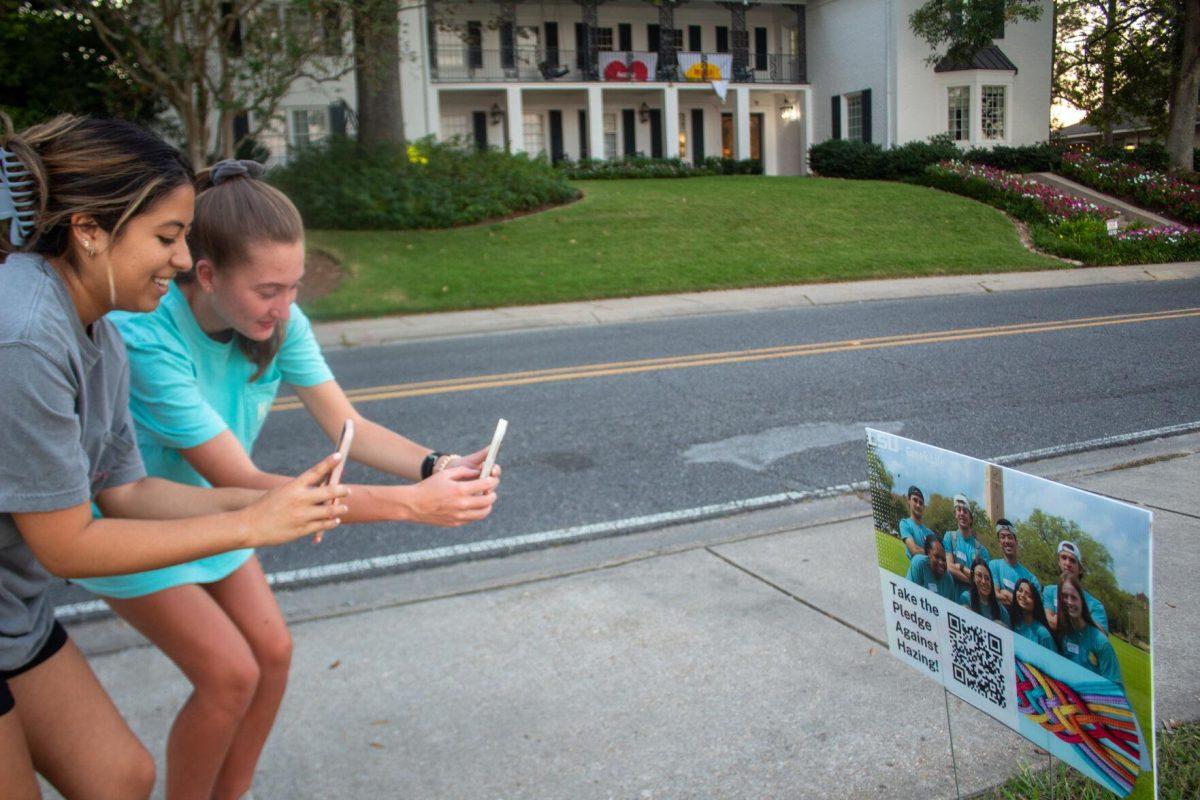 Sophomore LSU students Claudia Dominguez and Jewel Lewis scan QR codes during the Take a Walk and Take the pledge event on Friday, Sept. 23, 2022, on W Lakeshore Drive in Baton Rouge, La.