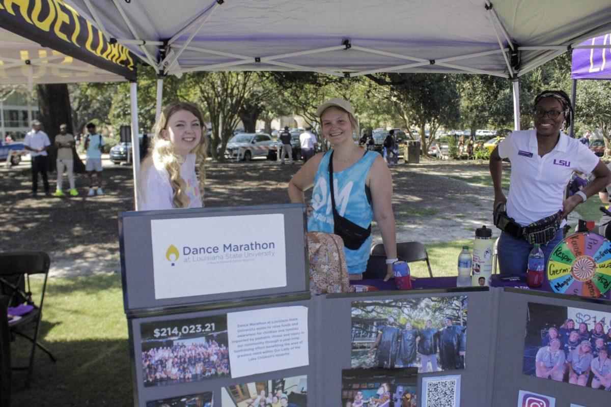 Dance Marathon booth workers show off their informational board at Fall Fest on Sept. 16, 2022, on the LSU Parade Ground.