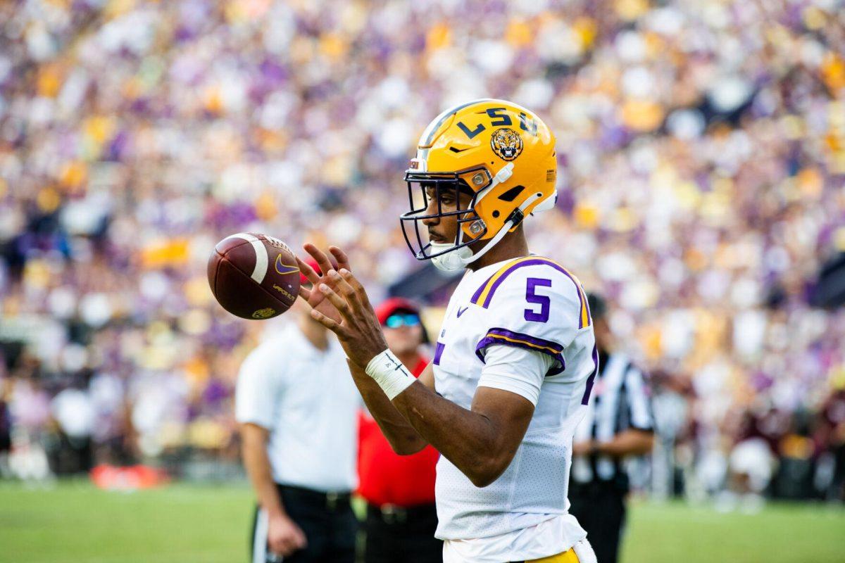 LSU football junior quarterback Jayden Daniels (5) catches a ball as he practices on the sidelines Saturday, Sept. 17, 2022 during LSU’s 31-16 win against Mississippi State at Tiger Stadium in Baton Rouge, La.