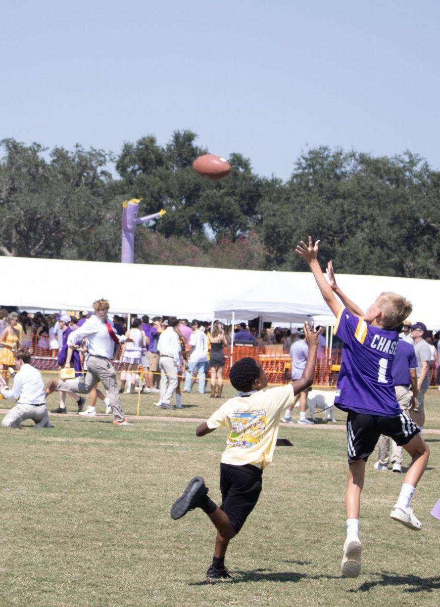 Two boys look to catch a pass at the LSU Family Weekend Tailgate on Saturday, Sept. 24, 2022, on the LSU Parade Ground in Baton Rouge, La.