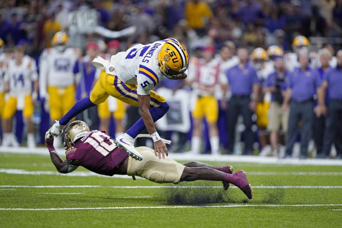 LSU quarterback Jayden Daniels (5) is upended by Florida State defensive back Jammie Robinson (10) on a carry in the second half of an NCAA college football game in New Orleans, Sunday, Sept. 4, 2022. Florida State won 24-23. (AP Photo/Gerald Herbert)