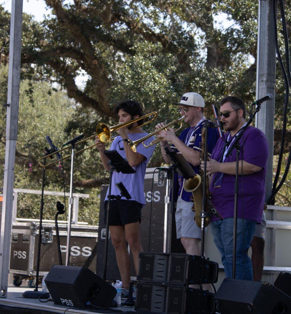 Three musicians perform on stage at the LSU Family Weekend Tailgate on Saturday, Sept. 24, 2022, on the LSU Parade Ground in Baton Rouge, La.