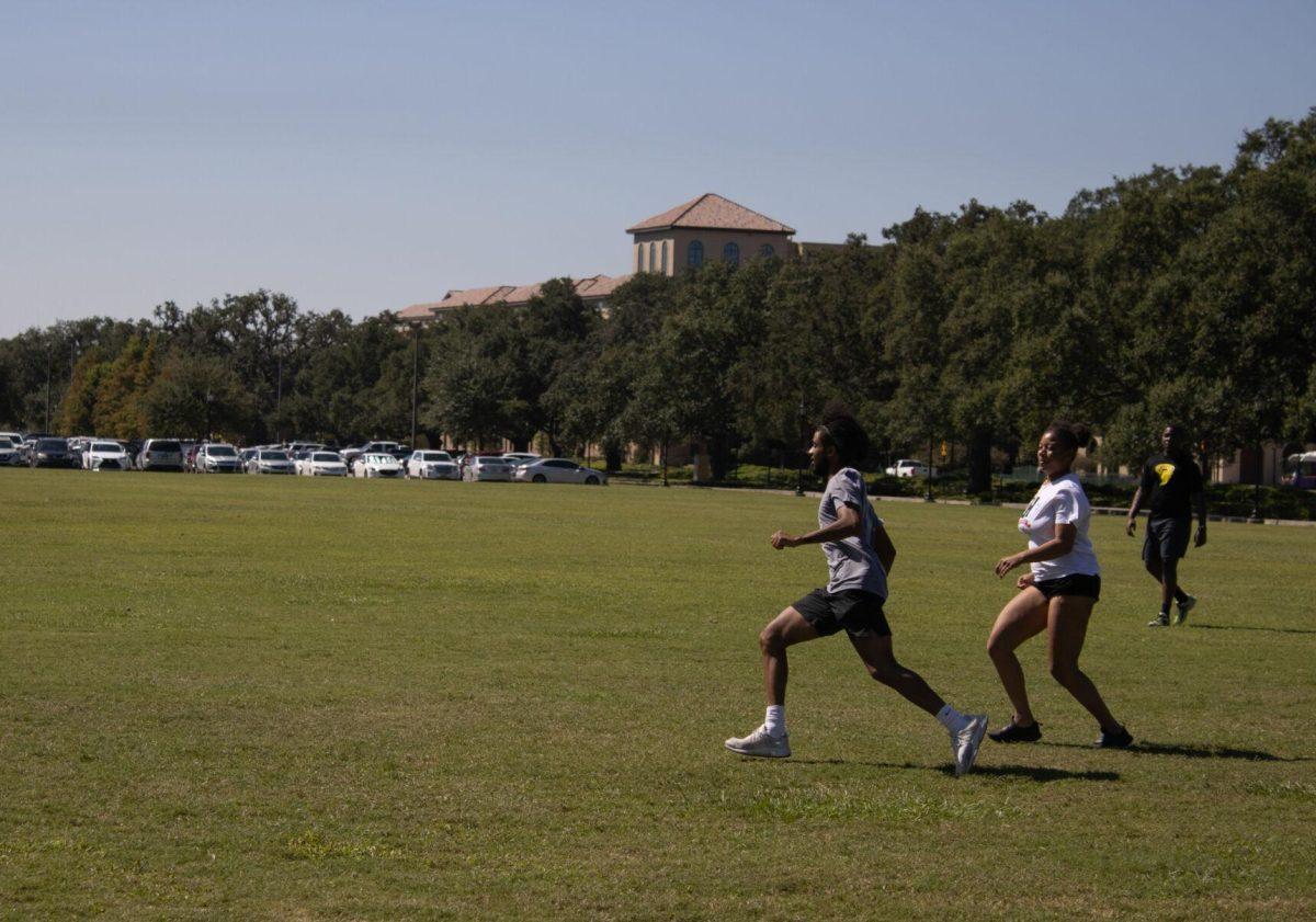 Two students participate in a game of capture the flag for jogging class on Wednesday, Sept. 14, 2022, at the field by the LSU Natatorium in Baton Rouge, La.