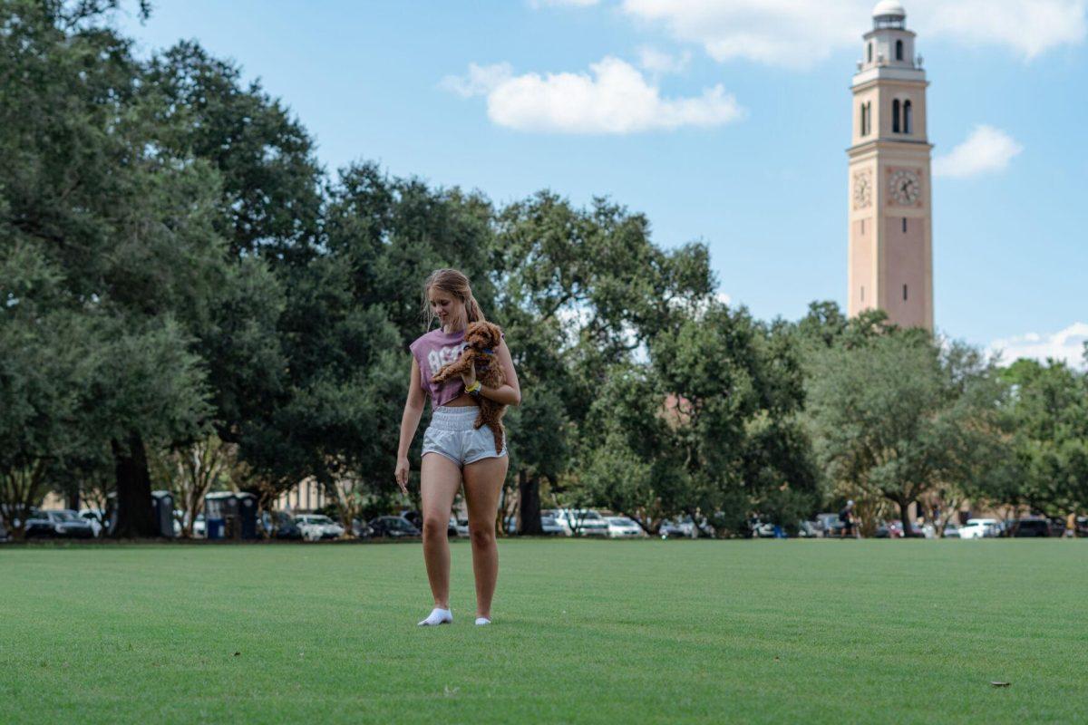 LSU kinesiology senior Caitlin Mathes carries her dog Cooper on Friday, Sept. 9, 2022, on the Parade Ground on Highland Road in Baton Rouge, La.