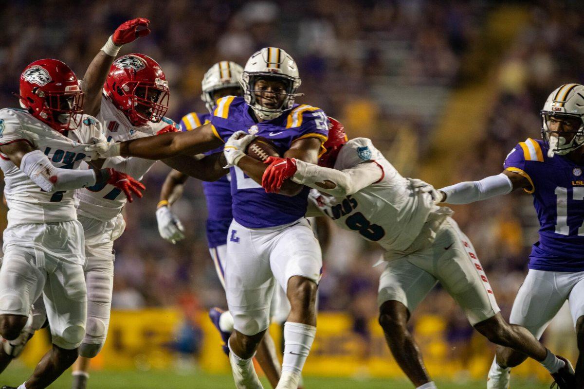 LSU football junior running back Noah Cain (21) guards and runs with the ball on Saturday, Sept. 24, 2022, during the LSU vs New Mexico game in Tiger Stadium.