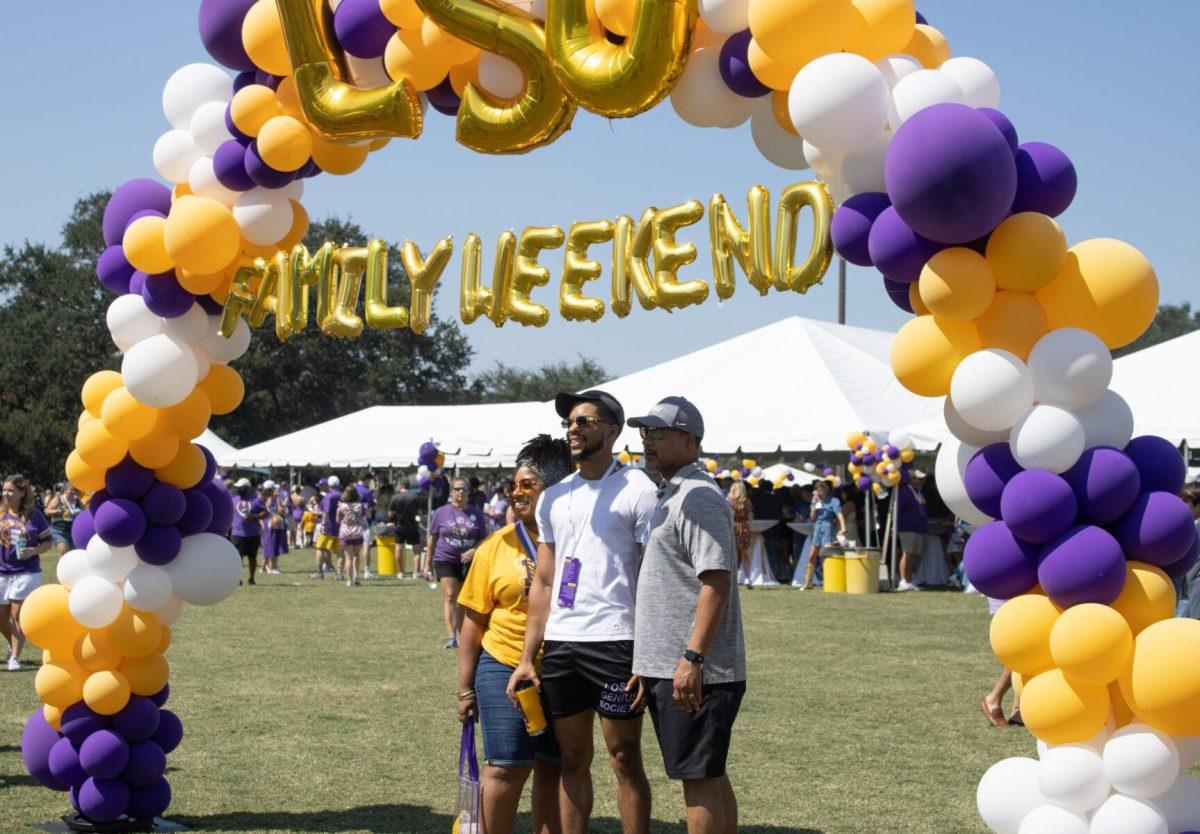 A family poses for a picture under a balloon arch at the LSU Family Weekend Tailgate on Saturday, Sept. 24, 2022, on the LSU Parade Ground in Baton Rouge, La.