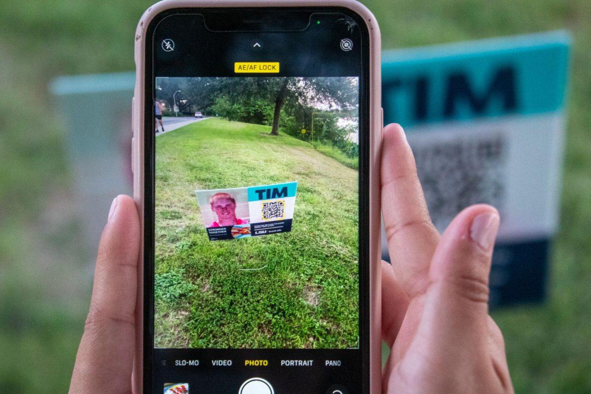 Student uses her phone to learn more about a hazing victim during the Take a Walk and Take the Pledge event on Friday, Sept. 23, 2022, on W Lakeshore Drive in Baton Rouge, La.