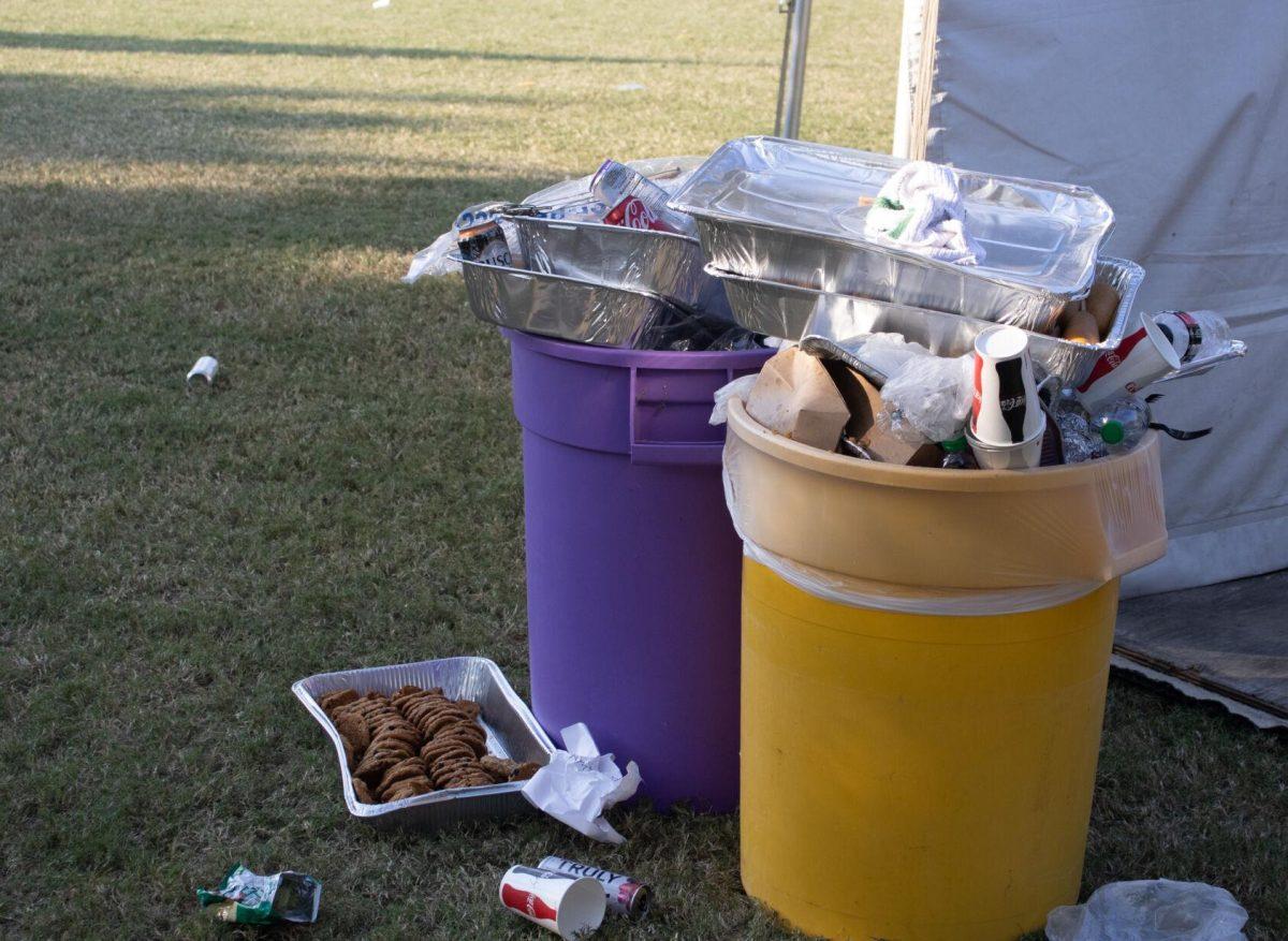 Overflowing garbage cans sit on the LSU Parade Ground after tailgating on Saturday, Sept. 24, 2022, in Baton Rouge, La.