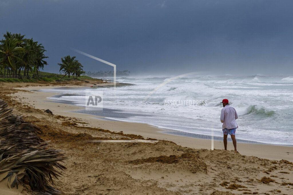 A man walks on the beach next to waves kicked up by Hurricane Fiona in Punta Cana, Dominican Republic, Monday, Sept. 19, 2022.(AP Photo/Ricardo Hernandez)