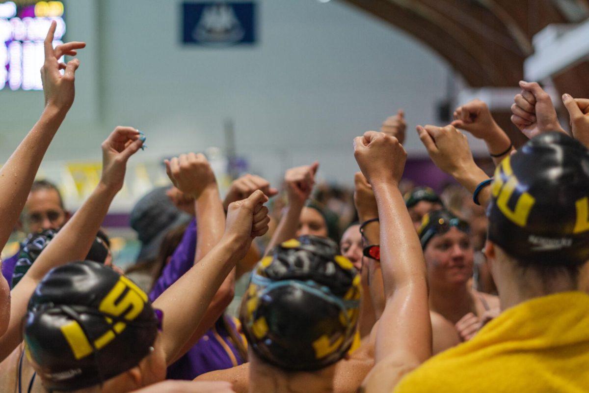 The LSU swim team raises their hands for a cheer on Friday, Sept. 23, 2022, after LSU&#8217;s victory over Tulane and Vanderbilt at the LSU Natatorium on Nicholson Drive in Baton Rouge, La.