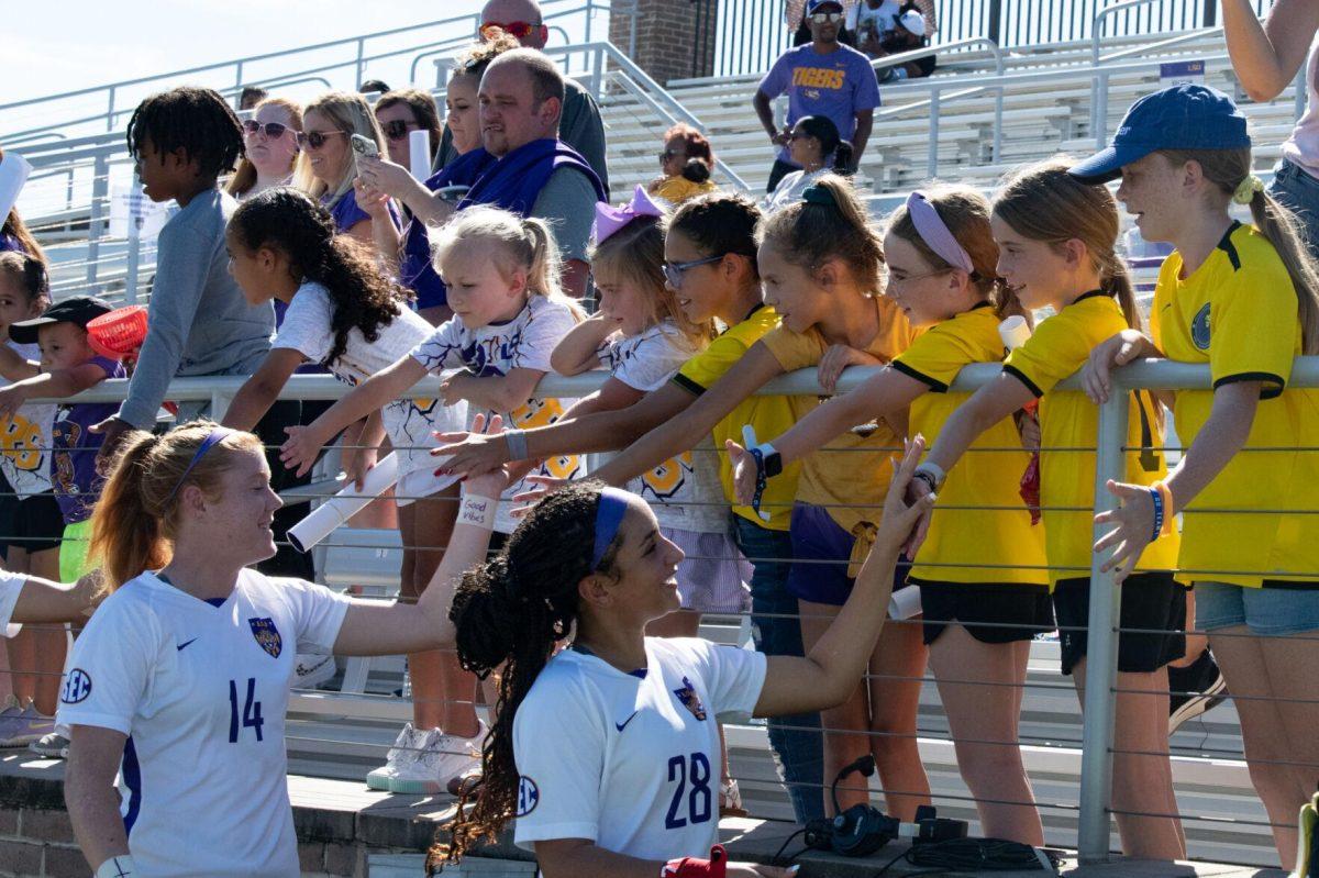 LSU soccer senior defender Anna Rockett (14) and sophomore defender Gianni Badon (28) give high fives to young fans on Sunday, Oct. 2, 2022, after LSU&#8217;s 3-2 win against University of Kentucky at LSU&#8217;s Soccer Stadium off Nicholson Drive.