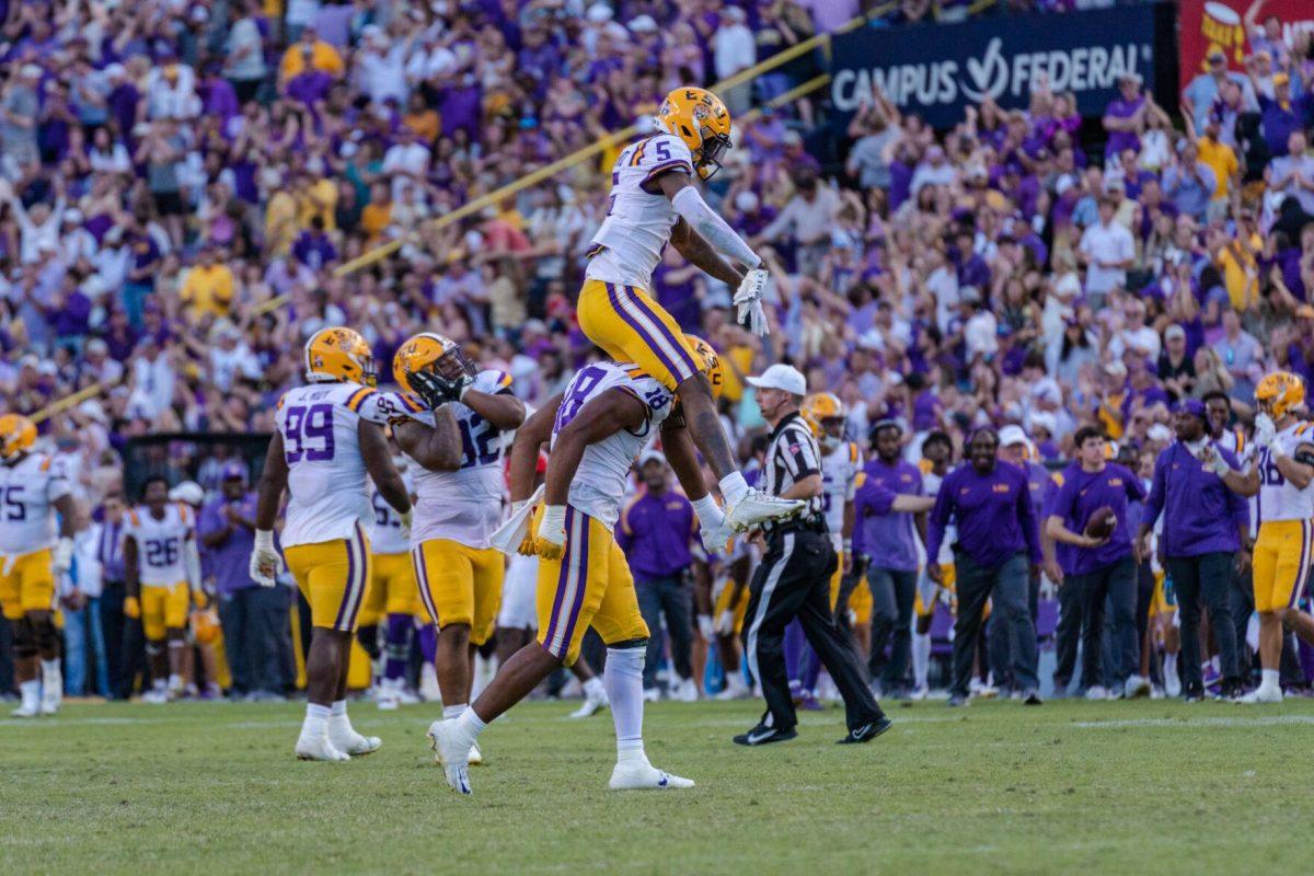 LSU football senior safety Jay Ward (5) leaps over junior defensive end BJ Ojulari (18) in celebration on Saturday, Oct. 22, 2022, during LSU&#8217;s 45-20 victory over Ole Miss in Tiger Stadium in Baton Rouge, La.