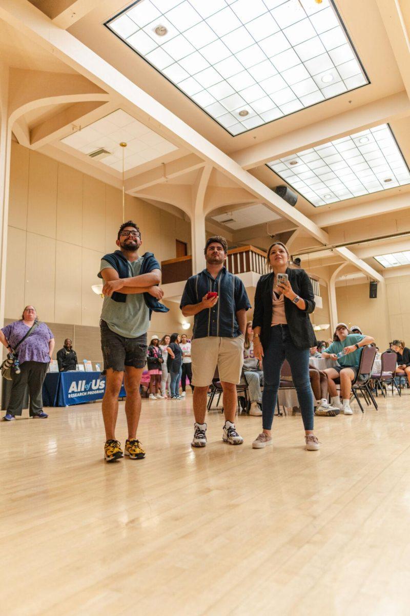 Three attendees look at the Kahoot! question on the big screen on Friday, Sept. 30, 2022, during Latinx Night at the LSU Union Ballroom.