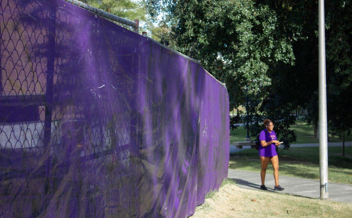 A purple privacy screen hangs from the fencing on Monday, Oct. 3, 2022, near the Enchanted Forest in Baton Rouge, La.