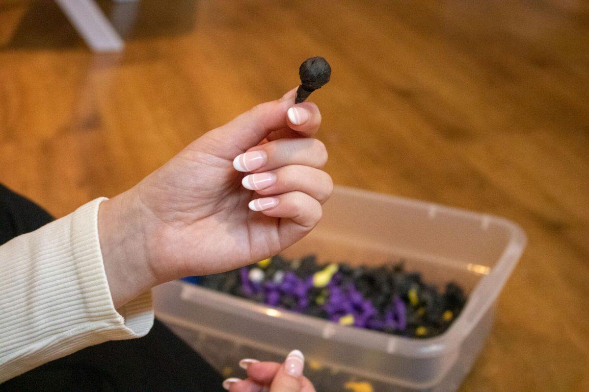 Zeta sorority member holds up a finished pomp on Wednesday, Oct. 19, 2022, in the Zeta Sorority house on West Lakeshore Drive in Baton Rouge, La.