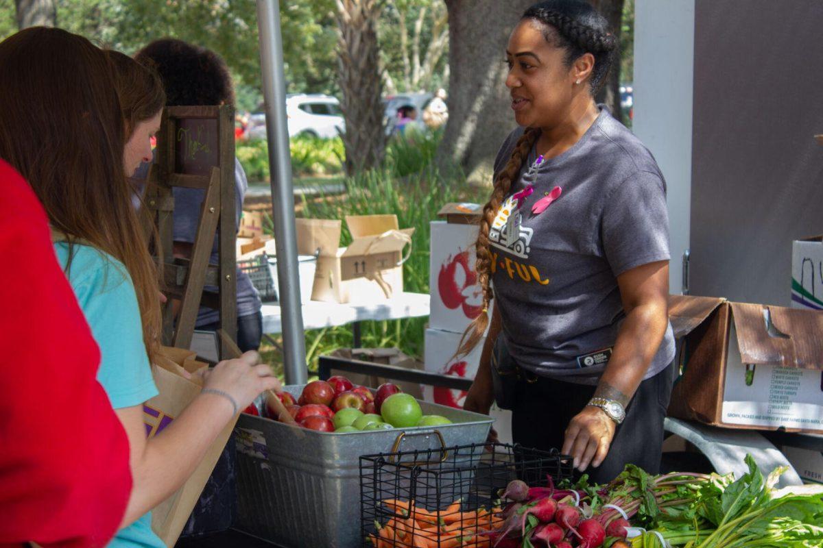 A woman hands out apples to LSU students on Wednesday, Oct. 5, 2022, on Tower Drive in Baton Rouge, La.