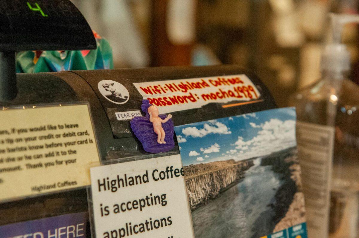 Photos, stickers, small informational signs, and a plastic king cake baby decorate the cash register&#160;on Saturday, Oct. 1, 2022,&#160;at Highland Coffees on Highland Road in Baton Rouge, La.