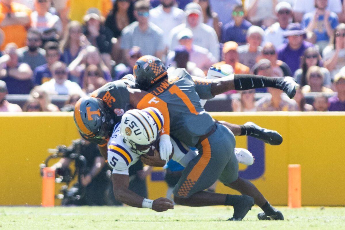 LSU junior quarterback Jayden Daniels (5) gets tackled by Tennessee Solon Page III (38) and Trevon Flowers (1) on Saturday, Oct. 8, 2022, during LSU's defeat to Tennessee 13-40 in Tiger Stadium.