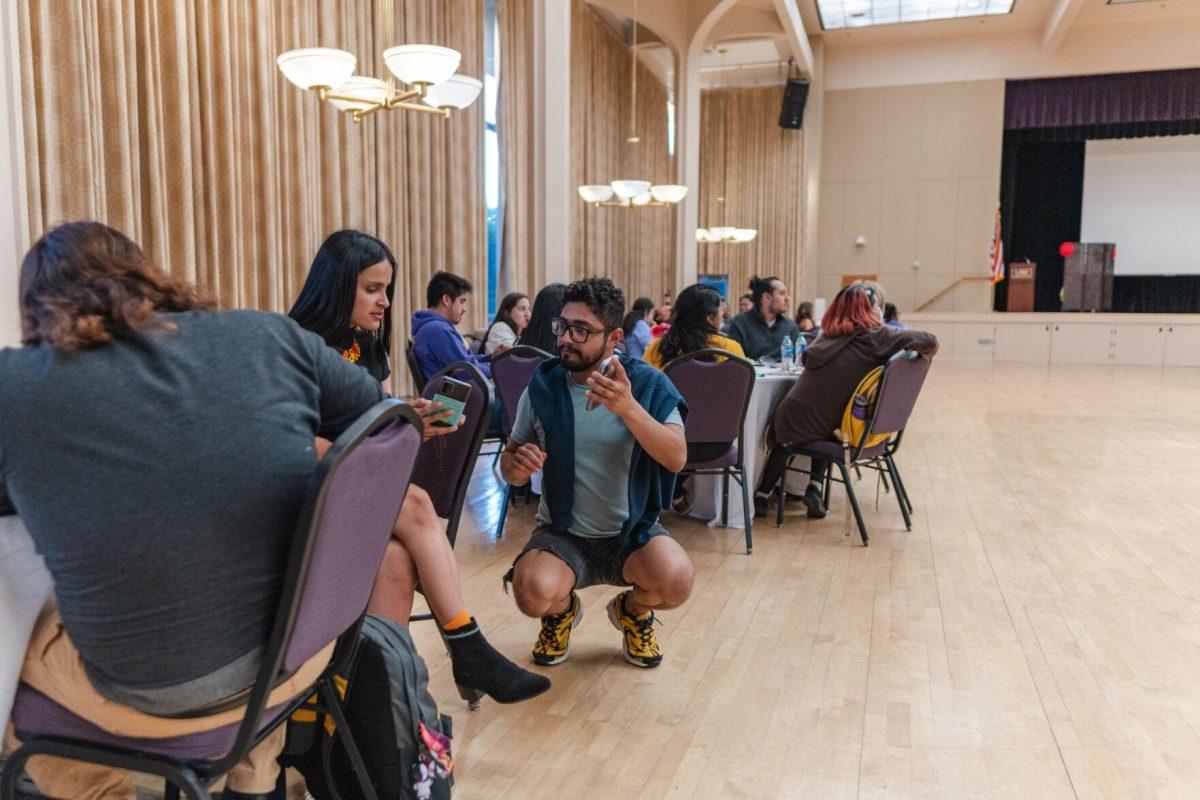 One student explains how to join a student organization&#8217;s group chat on Friday, Sept. 30, 2022, during Latinx Night at the LSU Union Ballroom.