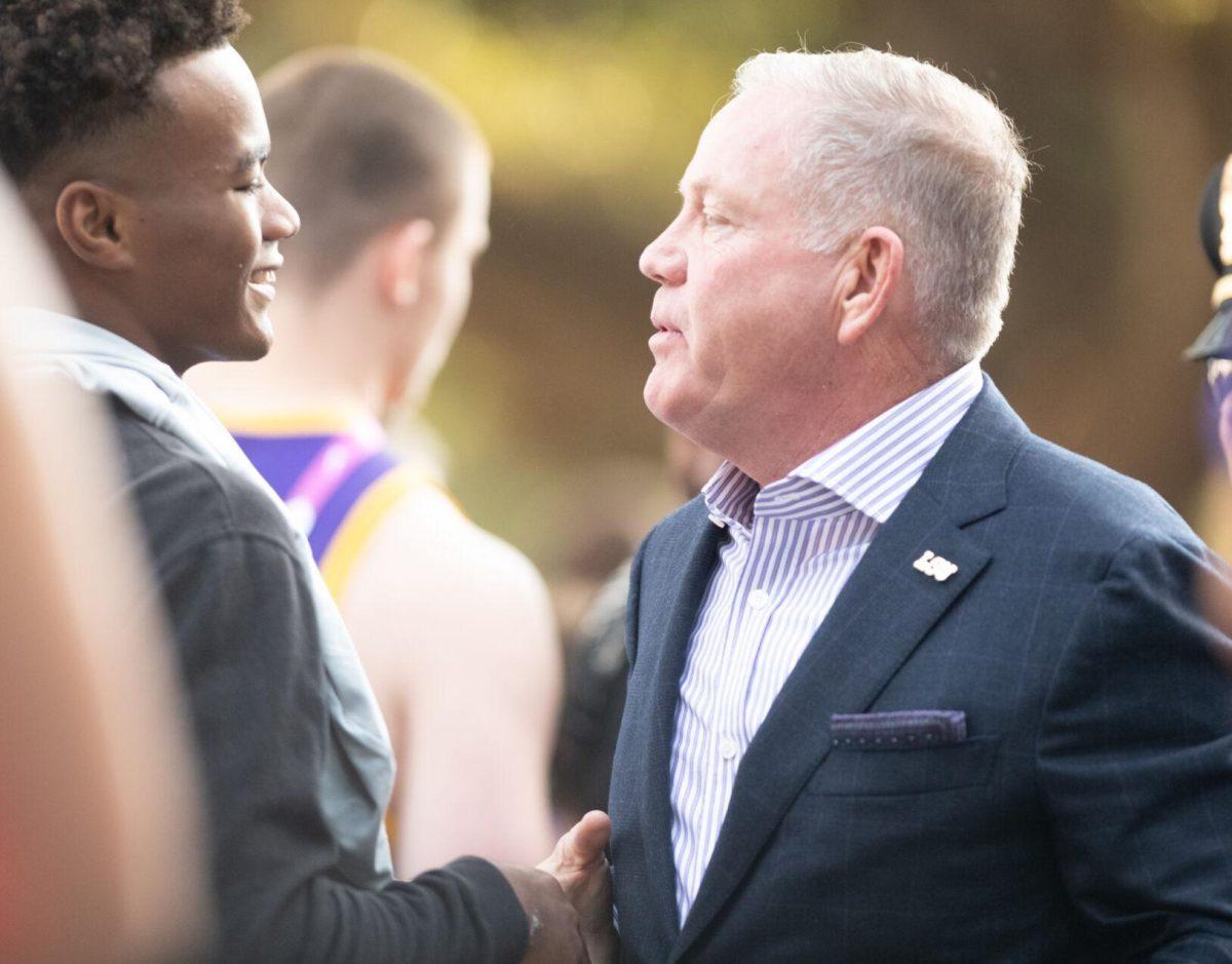 LSU head coach Brian Kelly welcomes a potential recruit before the start of the game against Tennessee on Saturday, Oct. 8, 2022, on North Stadium Drive.