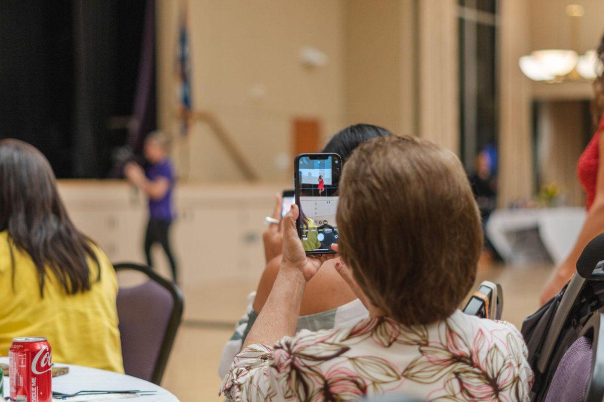 A woman photographs the dance instructor on Friday, Sept. 30, 2022, during Latinx Night at the LSU Union Ballroom.