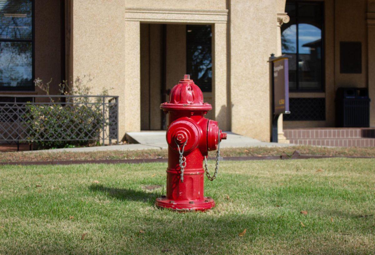 A red fire hydrant sits in the grass on Monday, Oct. 3, 2022, in front of Evangeline Hall in Baton Rouge, La.