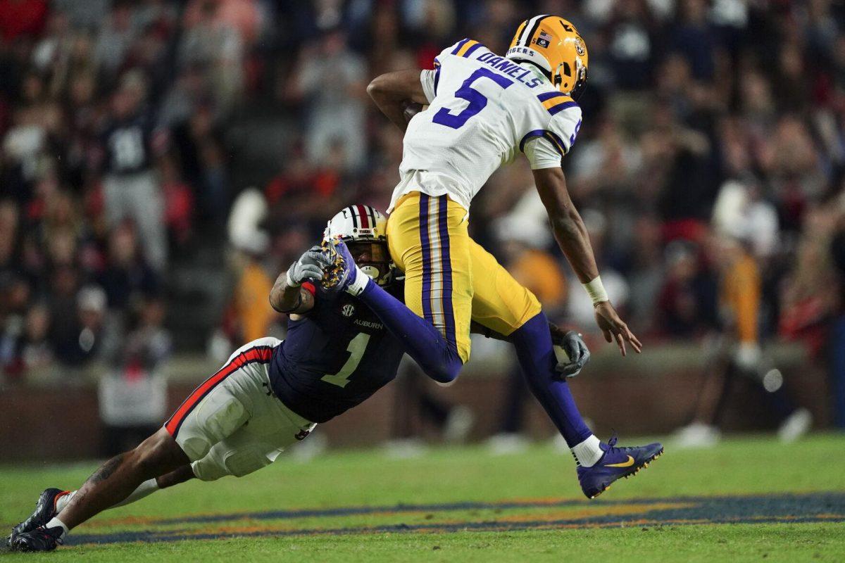 LSU quarterback Jayden Daniels (5) breaks away from Auburn safety Donovan Kaufman (1) in the first half of an NCAA college football game, Saturday, Oct. 1, 2022, in Auburn, Ala. (AP Photo/John Bazemore)