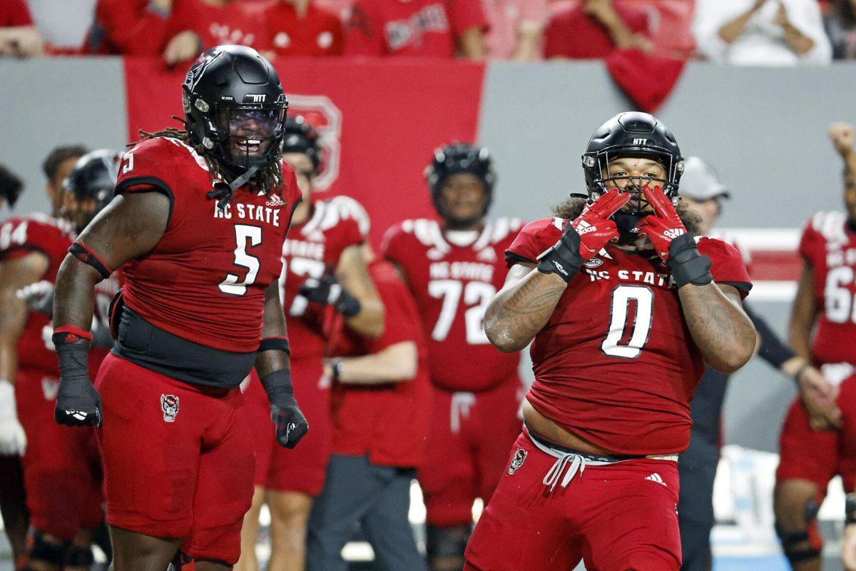 North Carolina State's Joshua Harris (0) and C.J. Clark (5) celebrate a sack during the first half of an NCAA college football game against Connecticut in Raleigh, N.C., Saturday, Sept. 24, 2022. (AP Photo/Karl B DeBlaker)