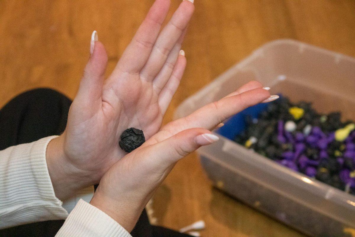 Zeta sorority member rolls up a sheet of tissue paper into a small ball to create a pomp on Wednesday, Oct. 19, 2022, in the Zeta Sorority house on West Lakeshore Drive in Baton Rouge, La.&#160;