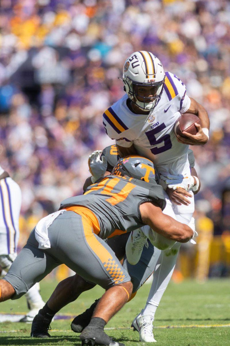 LSU junior quarterback Jayden Daniels (5) is tackled after running the ball on Saturday, Oct. 8, 2022, during LSU's defeat to Tennessee 13-40 in Tiger Stadium.