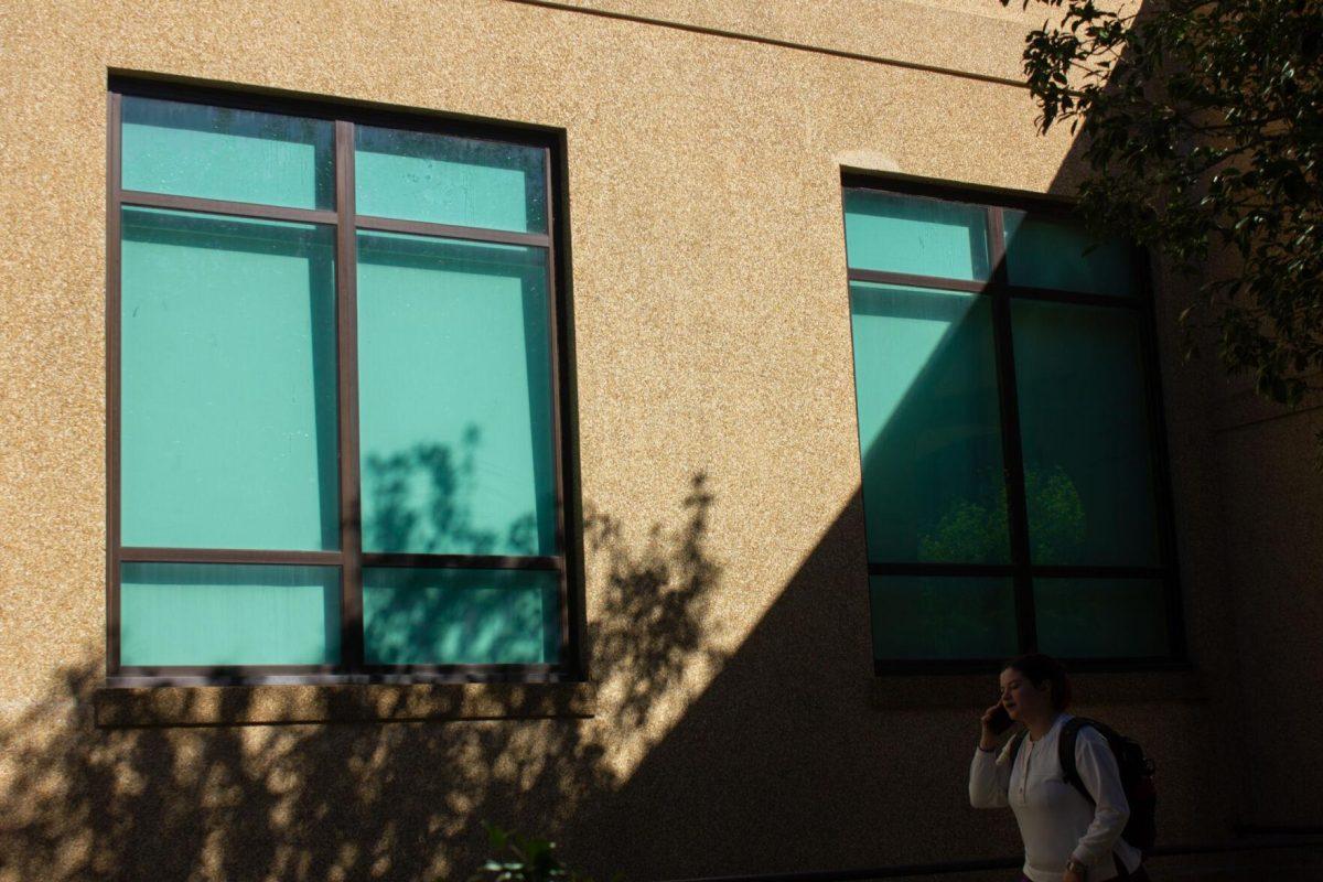 A student walks past the blue windows on Wednesday, Sept. 28, 2022, near Allen Hall in Baton Rouge, La.