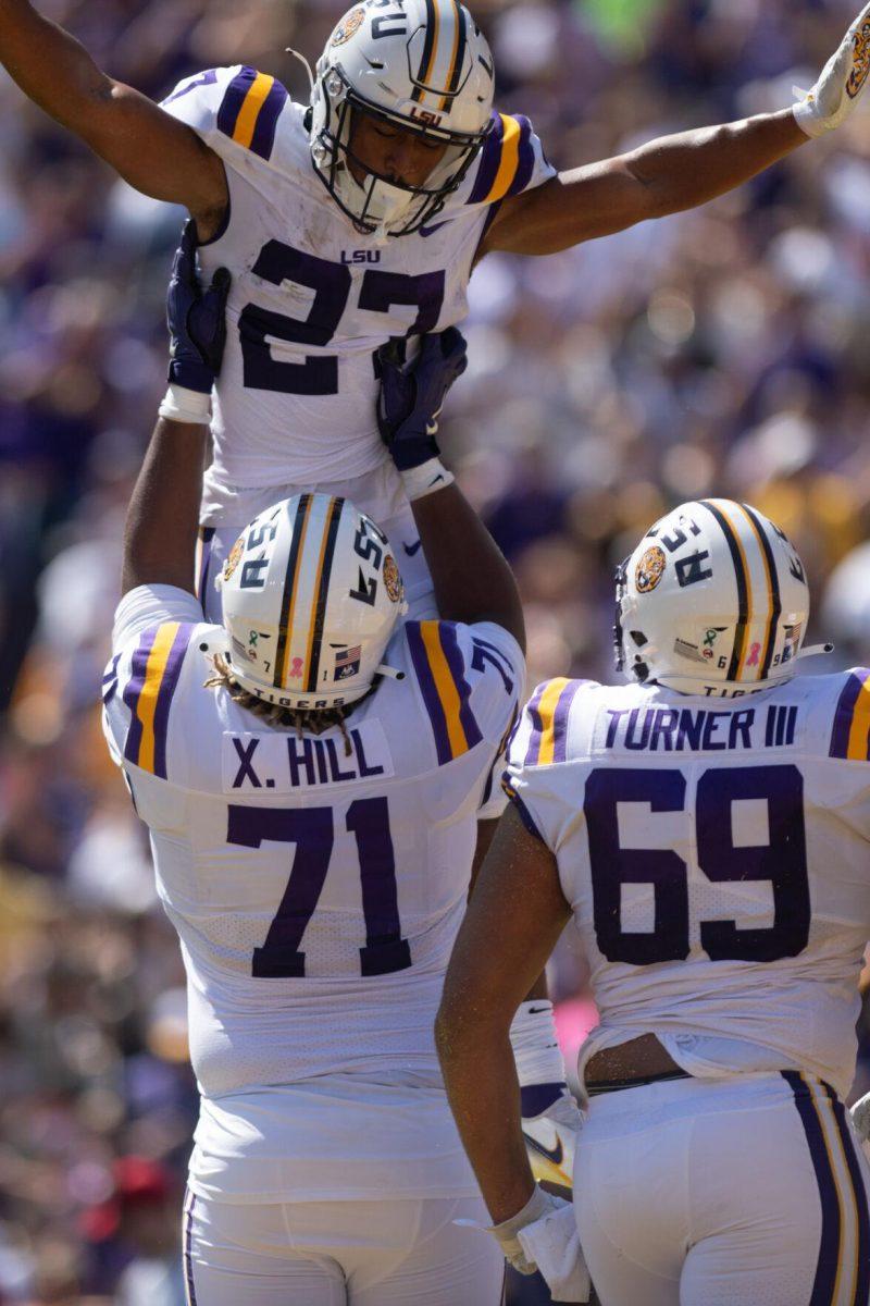 LSU sophomore Xavier Hill (71) lifts junior running back Josh Williams (27) in the air after Williams scored a touchdown on Saturday, Oct. 8, 2022, during LSU's defeat to Tennessee 13-40 in Tiger Stadium.