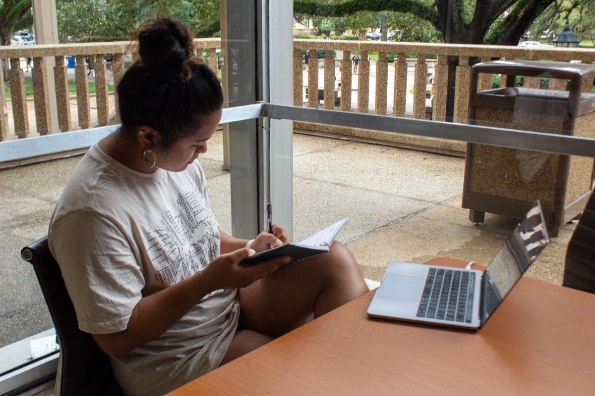 A student takes notes while studying on Sunday, October 23, 2022, in the Student Union on LSU Campus.