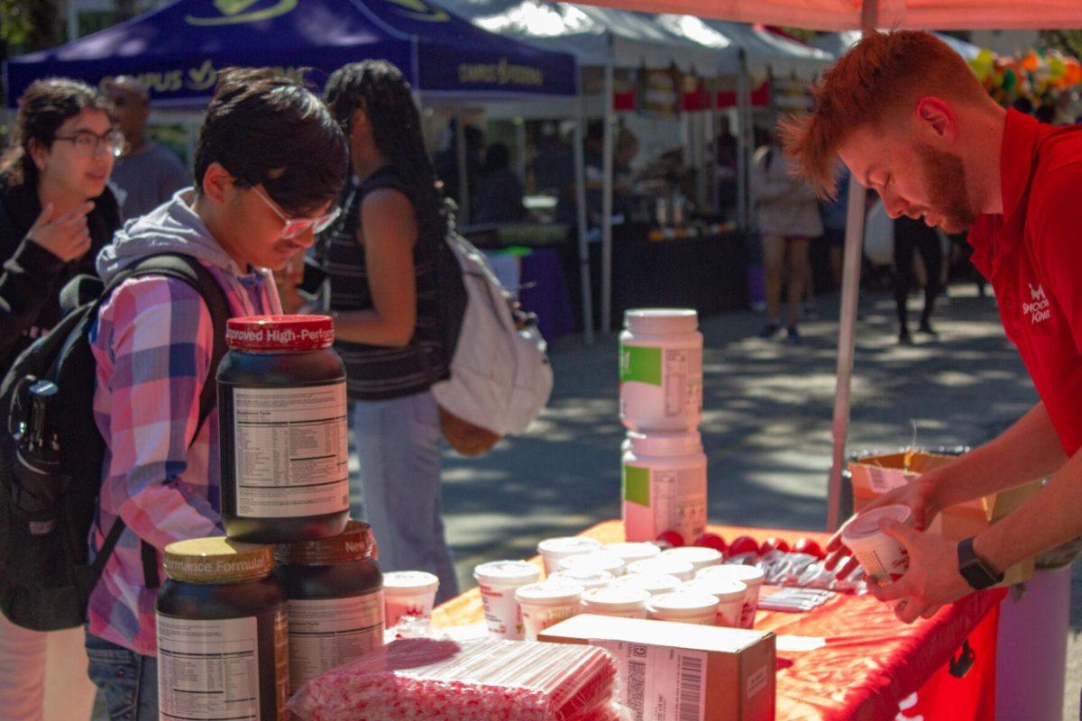 A Smoothie King employee hands out free samples to LSU students on Wednesday, Oct. 5, 2022, on Tower Drive in Baton Rouge, La.