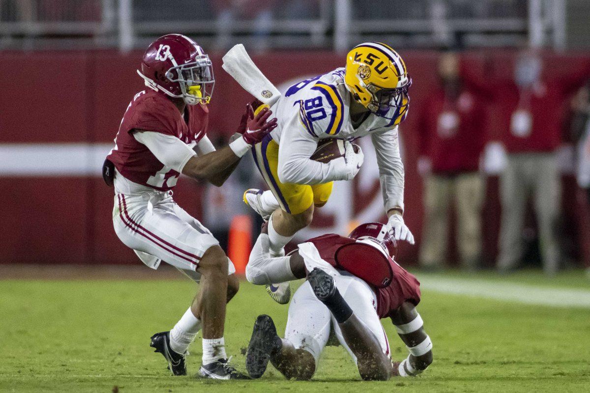 Alabama defensive back DeMarcco Hellams, bottom, upends LSU wide receiver Jack Bech (80) with Alabama defensive back Malachi Moore (13) trailing the play during the second half of an NCAA college football game, Saturday, Nov. 6, 2021, in Tuscaloosa, Ala. (AP Photo/Vasha Hunt)