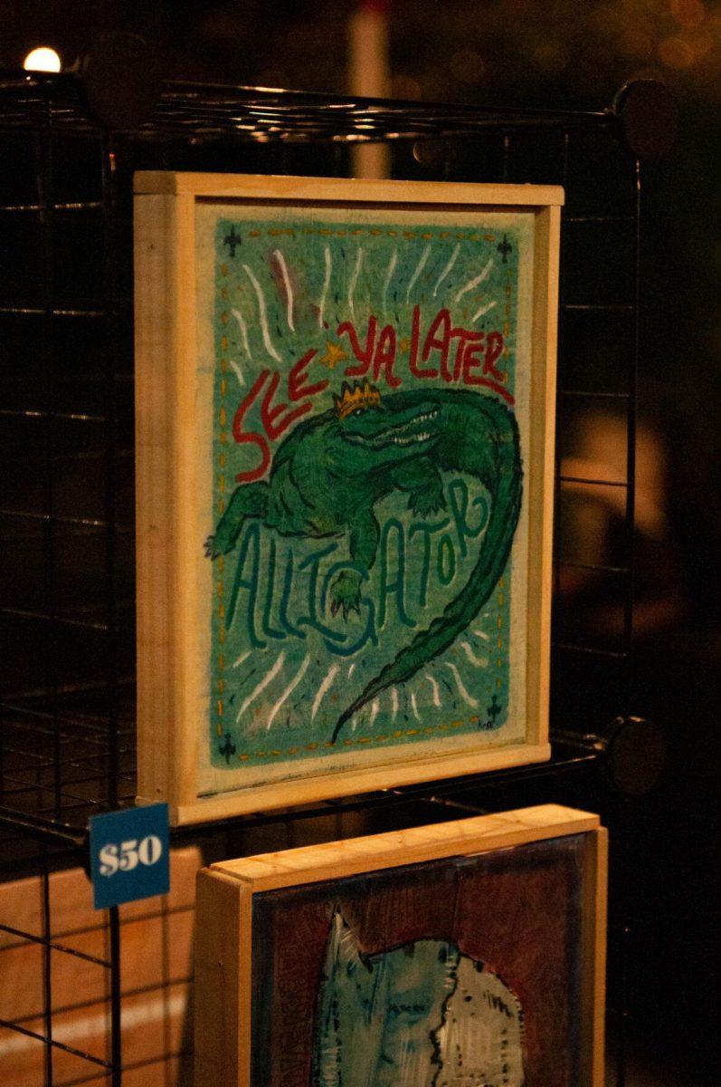 A canvas piece for sale reads "See Ya Later Alligator" on Friday, Nov. 18, 2022, at Mid City Merchant's White Light Night on Government Street in Baton Rouge, La.