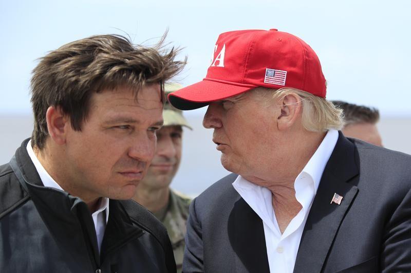 FILE - President Donald Trump talks to Florida Gov. Ron DeSantis, left, during a visit to Lake Okeechobee and Herbert Hoover Dike at Canal Point, Fla., March 29, 2019.&#160;