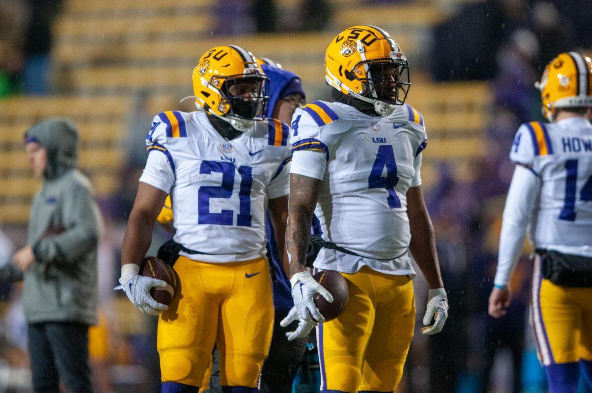 LSU football junior running back Noah Cain (21) and football (4) warm up in the rain on Saturday, Nov. 19, 2022, before the LSU vs UAB game in Baton Rouge, La.