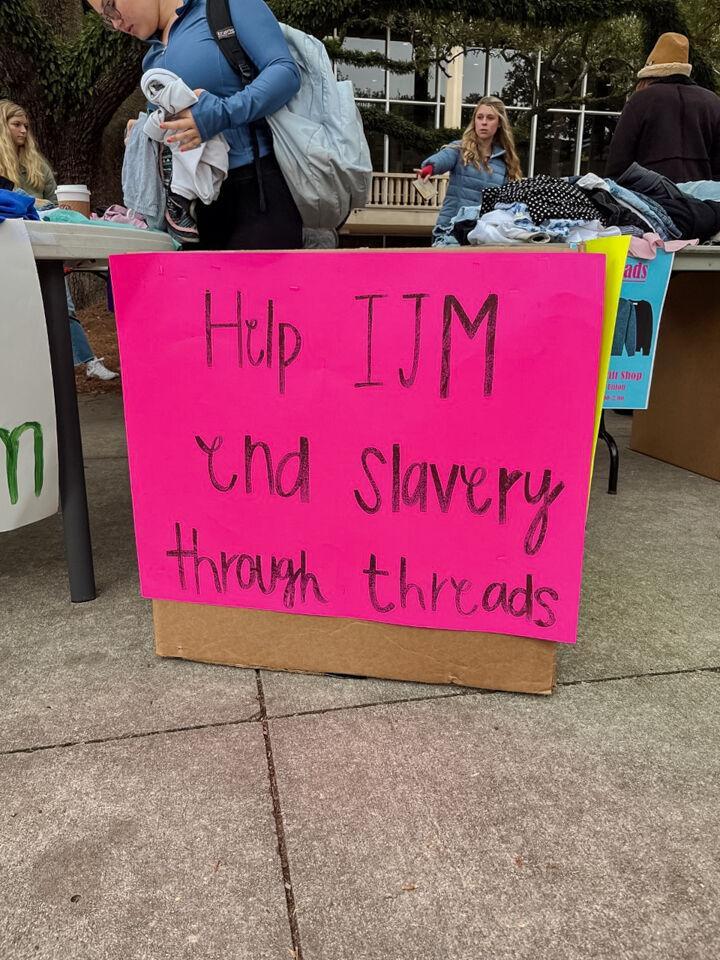 A sign reads "Help IJM end slavery through threads" on Wednesday, Nov. 16, 2022, in front of the LSU Student Union in Baton Rouge, La.