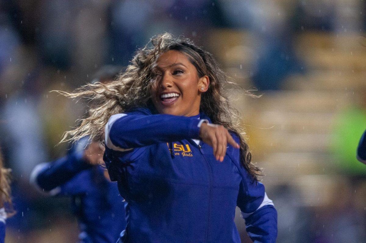 A member of the Tiger Girls dances and flips her hair in the rain on Saturday, Nov. 19, 2022, inside Tiger Stadium in Baton Rouge, La.