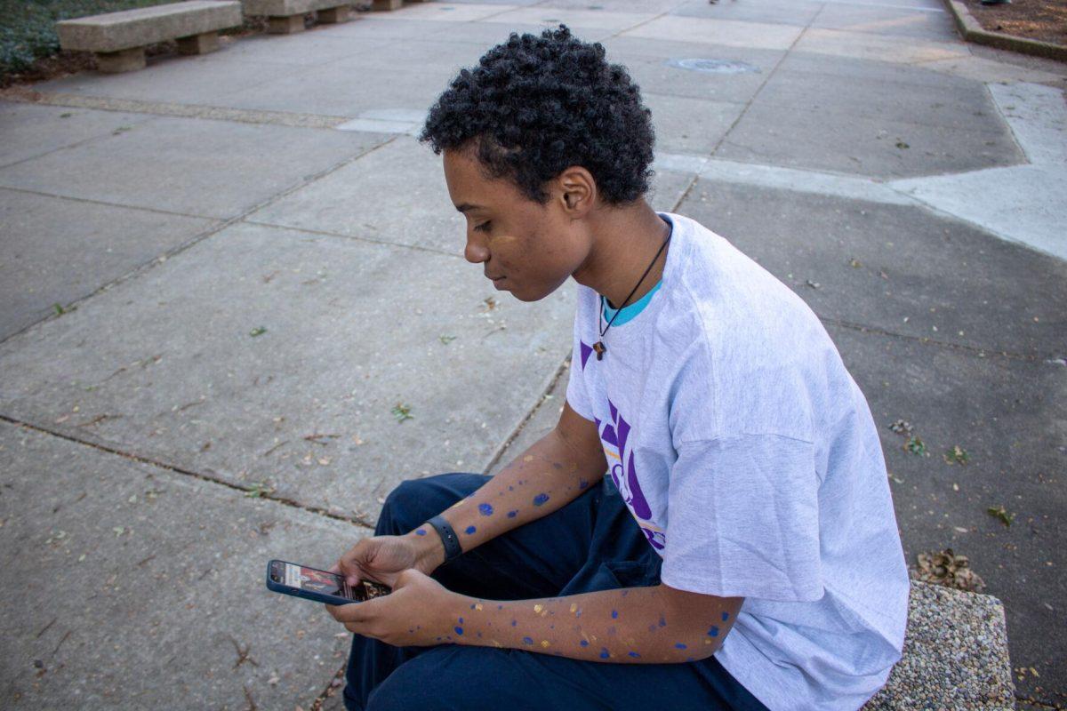 Sophomore student Jahbari Parquet views his phone on Sunday, Nov. 20, 2022, in the quad on LSU's campus.