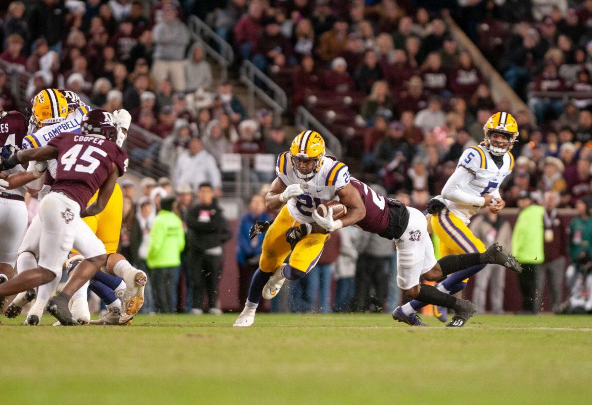 LSU football junior running back Noah Cain (21) pushes through the defense on Saturday, Nov. 26, 2022, during LSU's 23-38 loss against Texas A&amp;M at Kyle Field.