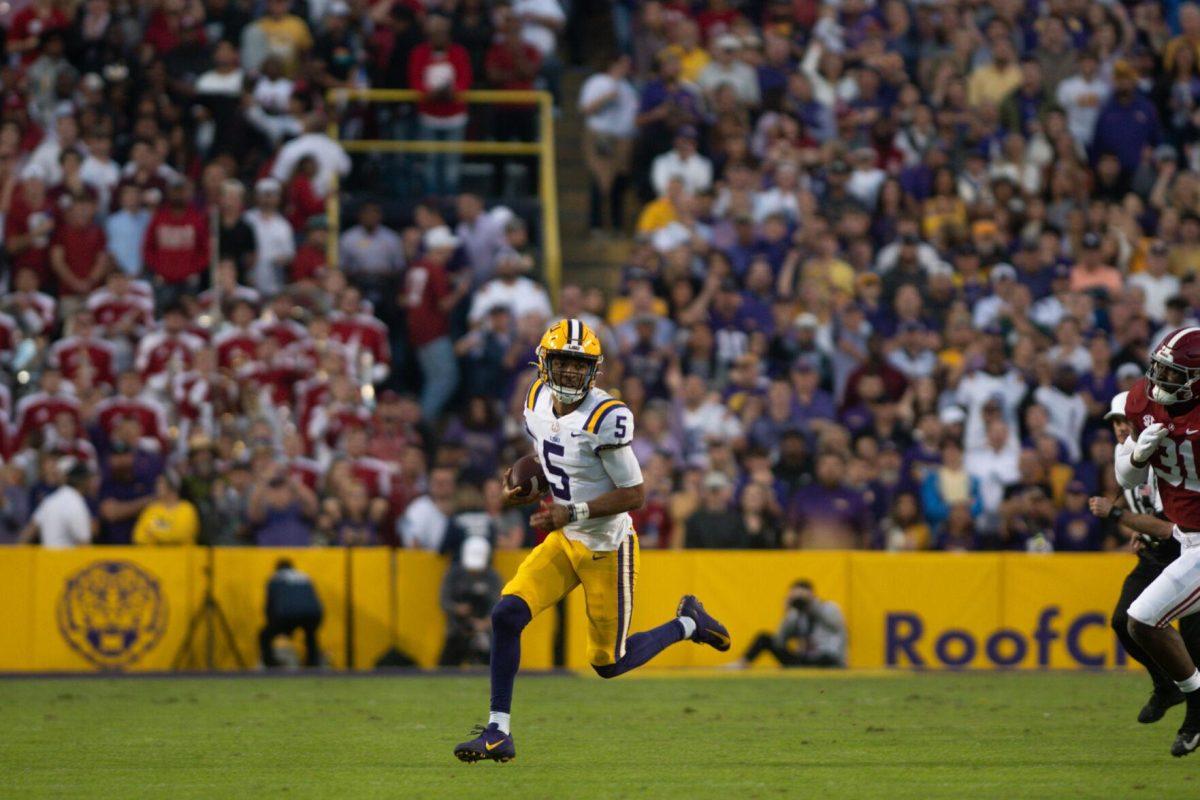 LSU football junior quarterback Jayden Daniels (5) darts across the field with the ball in his possession on Saturday, Nov. 5, 2022, during LSU&#8217;s 32-31 victory over Alabama in Tiger Stadium in Baton Rouge, La.