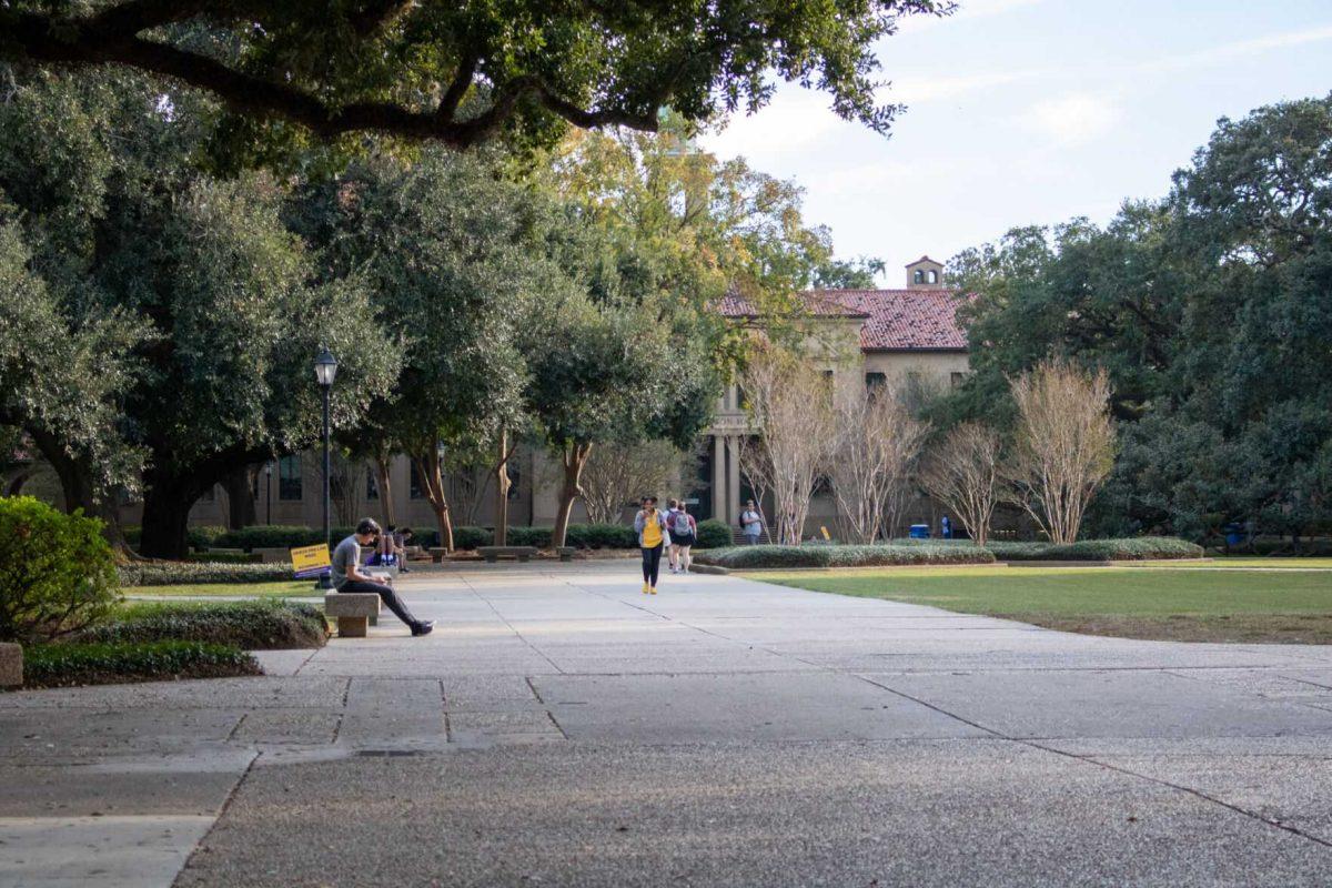 A student sits in the Quad as others walk past on Wednesdau, Nov. 9, 2022, in the quad on LSU Campus.