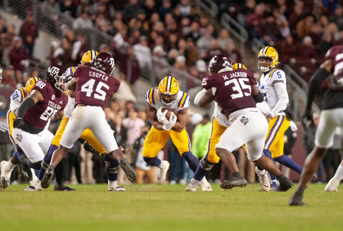 LSU football junior running back Noah Cain (21) rushes through the defense on Saturday, Nov. 26, 2022, during LSU's 23-38 loss against Texas A&amp;M at Kyle Field.