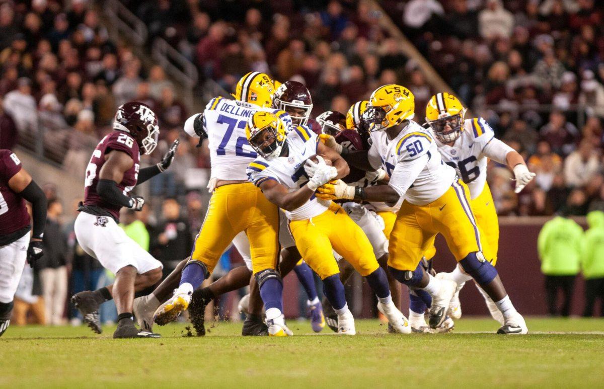 LSU football junior running back Noah Cain (21) fights to stay standing on Saturday, Nov. 26, 2022, during LSU's 23-38 loss against Texas A&amp;M at Kyle Field.